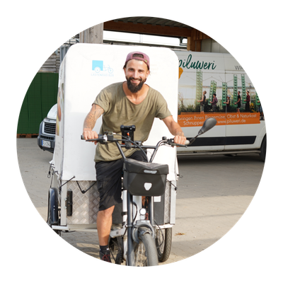 KI generiert: Mann auf Lastenrad, Hintergrund mit Lieferwagen "piluweri.de". Text: "Lastenrad".