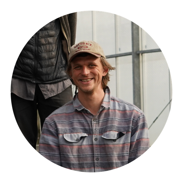 Unser Vorstandsmitglied Lukas Denne kniet in einem Grünkohlfeld.