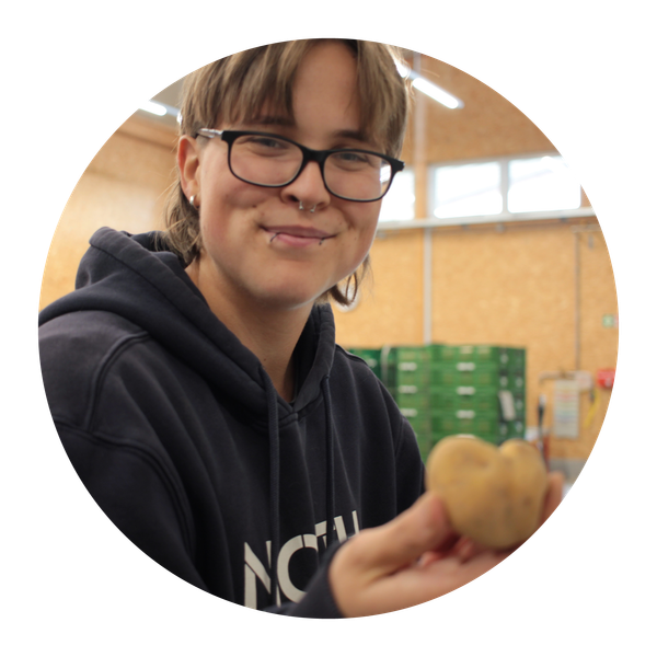 Unser Vorstandsmitglied Judith Muschiol hält eine Ranke Malabar-Spinat in der Hand.