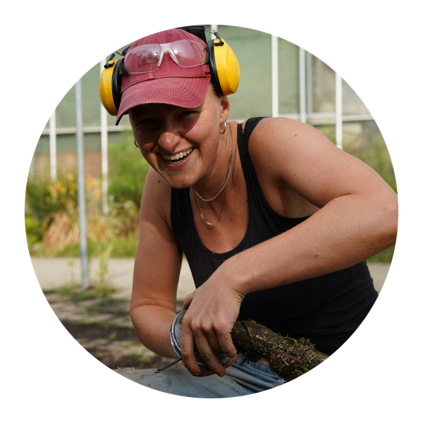 KI generiert: Eine Person mit roter Kappe und Gehörschutz lächelt beim Arbeiten im Garten.