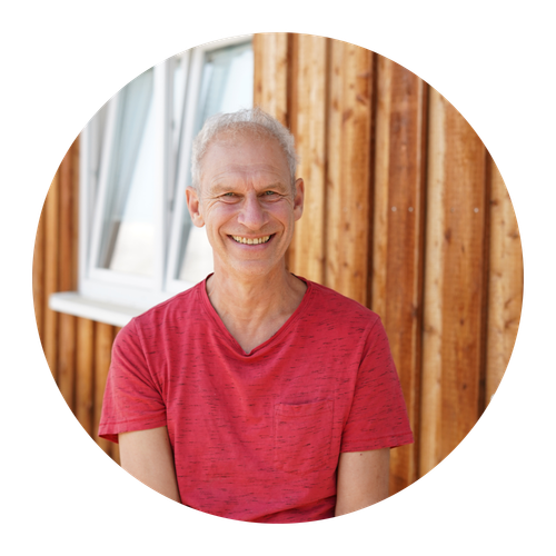 Michael Pickel. einer unsere Gründer, sitzt vor der Vermarktungshalle auf der Bank.