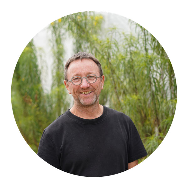 KI generiert: Ein lachender Mann mit Brille vor einer grünen Naturkulisse.