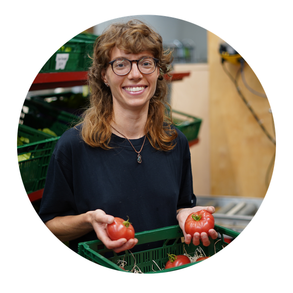 KI generiert: Eine Person hält Tomaten und steht vor Kisten in einem Lagerraum.