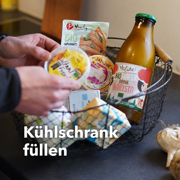 Ein Korb mit Butter, Käse und Milch, teilweise vegan. Text: Kühlschrank füllen.