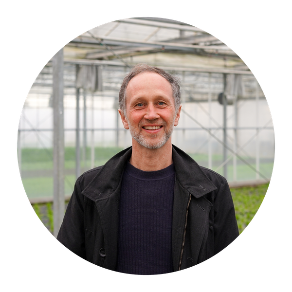 Unser Vorstandsmitglied Lukas Denne kniet in einem Grünkohlfeld.