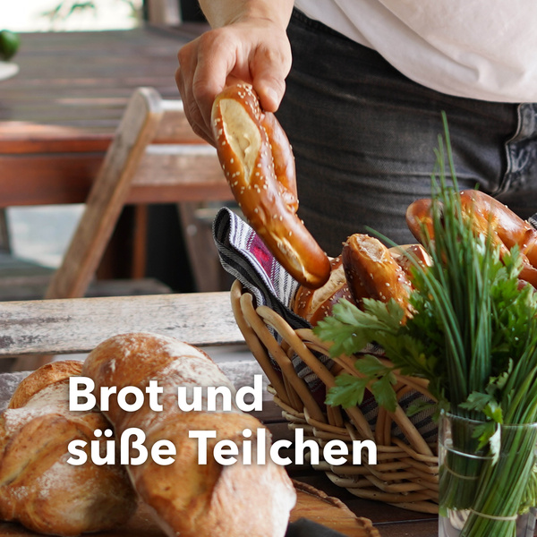Eine Person nimmt eine Brezel aus einem Brotkorb. Text: Brot und süße Teilchen.