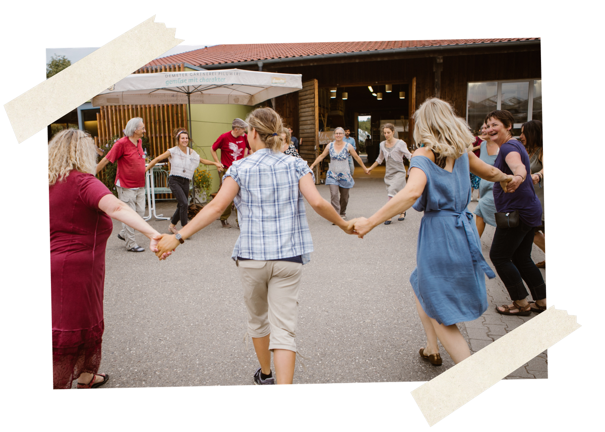 KI generiert: Eine Gruppe von Menschen hält sich an den Händen und tanzt im Freien in einem Kreis.