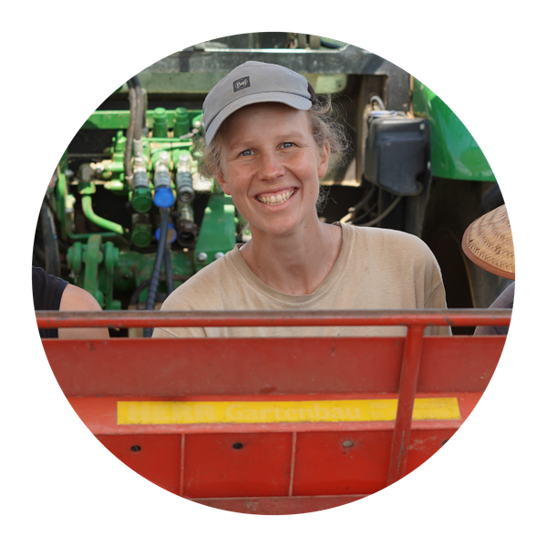 KI generiert: Eine Person mit Kappe lächelt vor einem Traktor; Text: "MEHR Gartenbau".