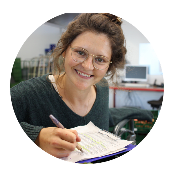 KI generiert: Eine lächelnde Person mit Brille schreibt auf einem Papier mit einer Büroklammer.