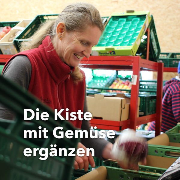 Eine Frau packt Radicchio in eine Gemüsekiste. Text: Die Kiste mit Gemüse ergänzen