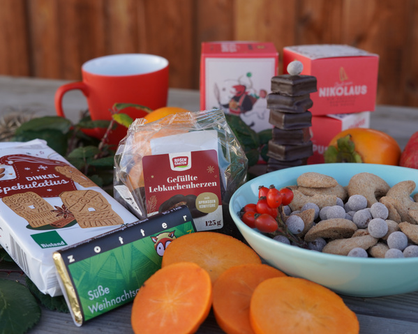 KI generiert: Eine Auswahl an weihnachtlichen Süßigkeiten und Keksen auf einem Tisch. Text: "Gefüllte Lebkuchenherzen".