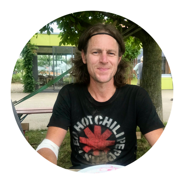 KI generiert: Eine Person in einem Park lächelt, trägt ein T-Shirt mit dem Text "RED HOT CHILI PEPPERS".