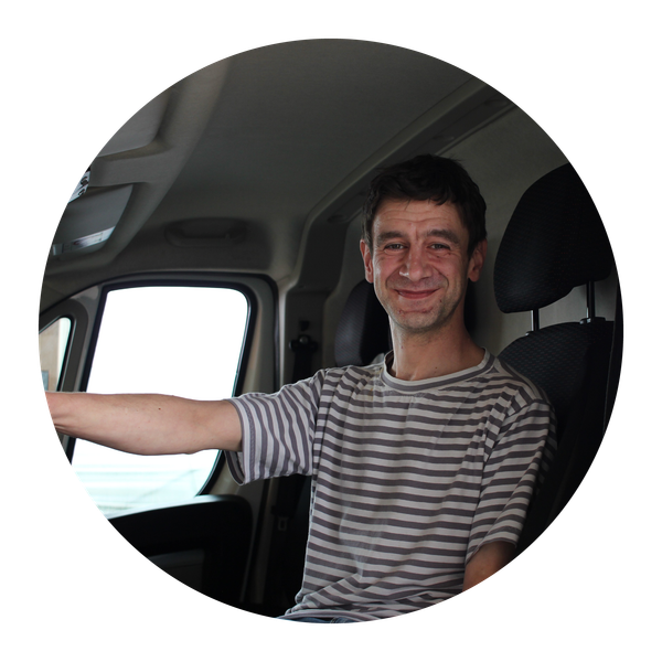 KI generiert: Eine Person sitzt lächelnd am Steuer eines Fahrzeugs.