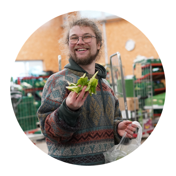 Unser Vorstandsmitglied Lukas Denne kniet in einem Grünkohlfeld.