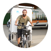 KI generiert: Mann auf Lastenrad, Hintergrund mit Lieferwagen "piluweri.de". Text: "Lastenrad".